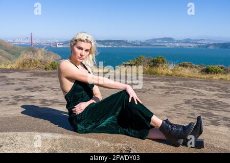 Moda in luoghi insoliti, donna in full length vestito in piedi in rovina di batteria pistola Foto Stock