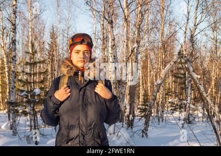 Felice giovane uomo, adolescente passeggiate nella foresta invernale. Foto Stock