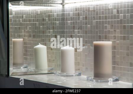 Le candele di closeup diffondono l'aroma sul tavolo in una sala spa. Bella composizione con candele grigie e bianche per trattamenti termali. Concetto di Zen e relax Foto Stock