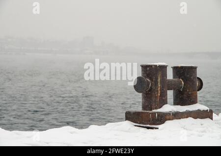 Arrugginito su un molo innevato. Foto Stock