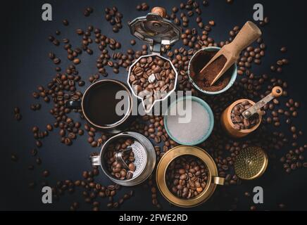 Vista dall'alto sul tavolo con attrezzatura per la preparazione del caffè circondato da chicchi di caffè. Preparazione del concetto di caffè. Foto Stock