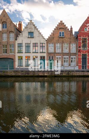 Facciate doppie ma dipinte in diverse tonalità. Tipiche case residenziali vicino ad un canale a Bruges, in Belgio. Foto Stock