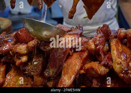 Char siu o arrosto di maiale preparato in una bancarella di cibo nel mercato Tai Yuen di Hong Kong. Foto Stock