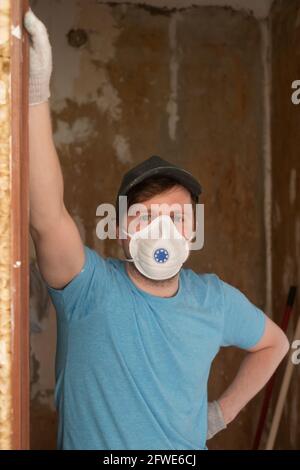 Giovane costruttore maschile in un respiratore protettivo Foto Stock