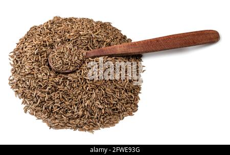 cucchiaio di legno su pila di frutti di cumino su sfondo bianco Foto Stock