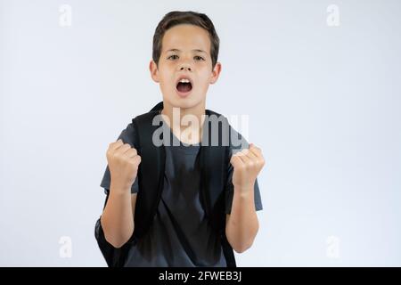 Bambino espressivo felice isolato su bianco. Ritorno a scuola. Felice vincere bambino con borsa Foto Stock