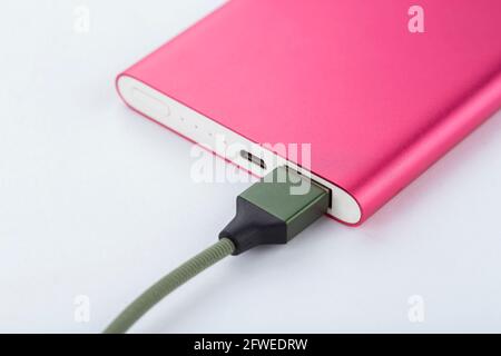 Power bank per caricare i dispositivi mobili. Caricabatterie rosa per smartphone con power bank. Batteria. Batteria esterna per dispositivi mobili su un backgro bianco Foto Stock