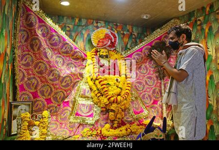 Beawar, Rajasthan, India, 22 maggio 2021: Un prete che indossa una maschera protettiva offre preghiere in occasione Mohini Ekadashi al tempio Khatu Shyam di Beawar. Shyam è un nome e una manifestazione di Barbareek, nipote di Bhim e Hidimba a Mahabharata. Credit: Sumit Saraswat/Alamy Live News Foto Stock