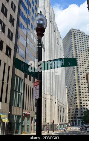 Boston, USA - 1 agosto 2013: Cartello stradale all'angolo tra Arch Street e Milk Street a Boston sotto un cielo nuvoloso e soleggiato Foto Stock