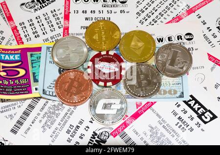Babylon, New York, USA - 17 maggio 2021: Monete di Bitcoin, etherum, litecoin e altri in cima ai biglietti della lotteria denaro e biglietti della lotteria. Foto Stock