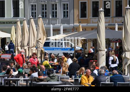 Dresda, Germania. 22 maggio 2021. La gente si siede nelle aree di ristorazione all'aperto di ristoranti e caffè a Neumarkt, mentre una polizia auto pattugliare in background. Credit: Robert Michael/dpa-Zentralbild/dpa - ATTENZIONE: USA solo in formato completo/dpa/Alamy Live News Foto Stock