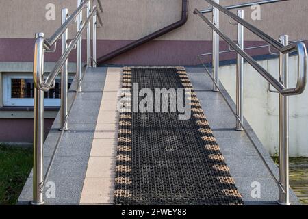 Passerella inclinata circondata da corrimano lucidi con rivestimento antiscivolo progettato per il sollevamento su sedia a rotelle o neonati in pRAM. Concetto: Protezione sociale Foto Stock