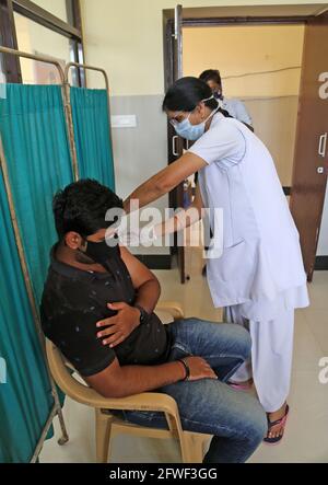 Beawar, Rajasthan, India, 22 maggio 2021: Un medico Manju Gupta inocula un giovane con una prima dose di vaccino corona al centro di vaccinazione COVID-19 a Beawar. Credit: Sumit Saraswat/Alamy Live News Foto Stock