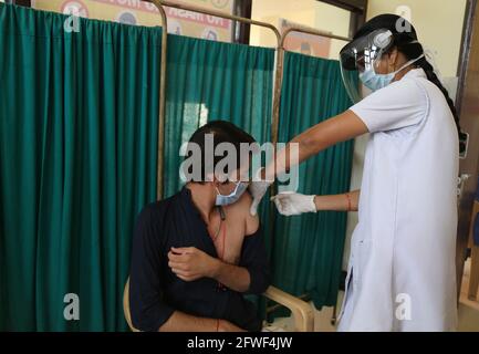 Beawar, Rajasthan, India, 22 maggio 2021: Un medico Manju Gupta inocula un giovane con una prima dose di vaccino corona al centro di vaccinazione COVID-19 a Beawar. Credit: Sumit Saraswat/Alamy Live News Foto Stock