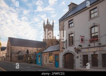 Ennis, Irlanda - Settembre 10 2016: Abbey Street e Ennis Friary nel pittoresco e affascinante centro storico di Ennis, Irlanda con tramonto dorato o alba Foto Stock