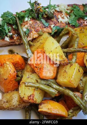 Salmone alla griglia con patate e verdure al forno Foto Stock