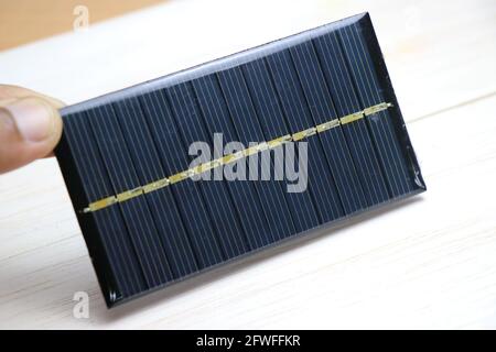 Mini pannello solare chiamato anche come mini cella solare che è molto piccolo nella dimensione tenuto in mano che produce elettricità quando esposta alla luce solare Foto Stock