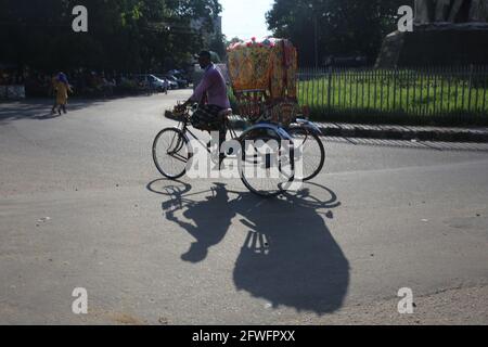 Dhaka, Bangladesh. 22 maggio 2021. Un estrattore di risciò sta attraversando la strada nel pomeriggio molto caldo dell'estate a Dhaka, Bangladesh il 22 maggio 2021. Credit: Md. Rakibul Hasan/ZUMA Wire/Alamy Live News Foto Stock