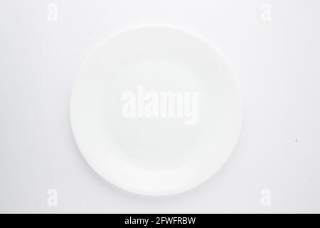 Piastra in ceramica bianca, forme diverse di un vasellame bianco vuoto in ceramica disposto su uno sfondo bianco testurizzato. Foto Stock
