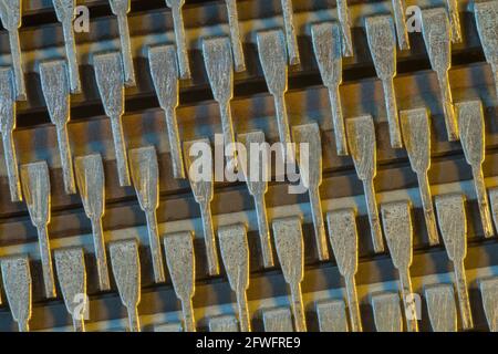 Macrofotografia dei pin del connettore del microchip semiconduttore (marchio Mitsubishi). Per componenti elettronici astratti, piedini di uscita microchip, astratto industriale. Foto Stock