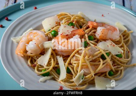 Spaghetti di frumento con gamberetti e piselli. Foto Stock