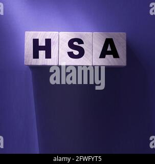 L'abbreviazione HSA è scritta su cubi di legno sul dorso rosso. Concetto. Conto di risparmio di salute. Foto Stock