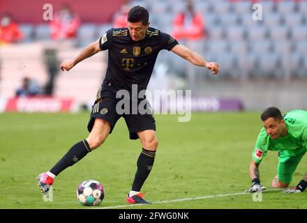 Monaco, Germania. 22 maggio 2021. Calcio: Bundesliga, FC Bayern München - FC Augusta, giorno 34 ad Allianz Arena. Robert Lewandowski (l) di Monaco segna il traguardo per 5:2 contro il portiere di Augusta Rafal Gikiewicz. NOTA IMPORTANTE: In conformità con le norme del DFL Deutsche Fußball Liga e del DFB Deutscher Fußball-Bund, è vietato utilizzare o utilizzare fotografie scattate nello stadio e/o della partita sotto forma di sequenze di immagini e/o serie di foto simili a video. Credit: Matthias Schrader/AP-Pool/dpa/Alamy Live News Foto Stock