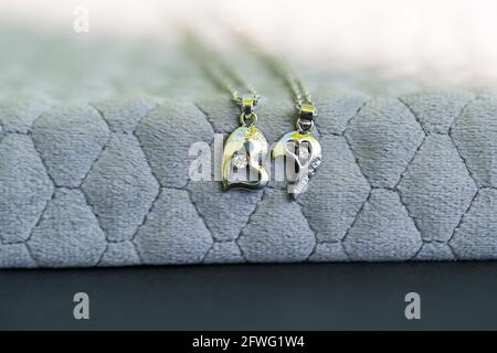 Coppia Set collana pendente per gli amanti due metà di un cuore closeup. Messa a fuoco selettiva Foto Stock