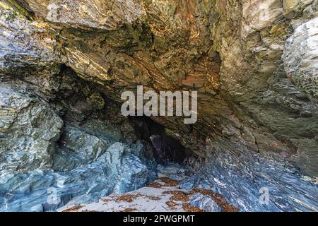 L'ingresso alla Grotta di Merlin, al Castello di Tintagel, a Tintagel, in Cornovaglia, Regno Unito Foto Stock