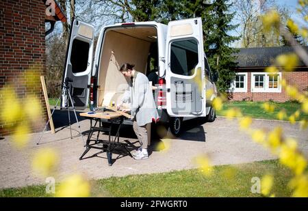 03 aprile 2021, bassa Sassonia, Großenmeer: Greta Thomas e Hannes Wehrmann lavorano sulla loro Mercedes-Benz Sprinter, che la coppia si convertì in un campervan con le proprie mani. Foto: Hauke-Christian Dittrich/dpa Foto Stock