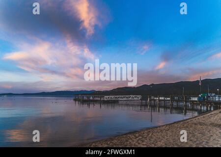 Nuvole colorate sul lago Tahoe California dopo il tramonto. Riflesso di nuvole colorate in acqua. Foto Stock