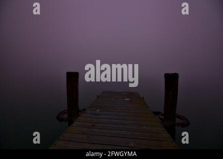 Ormeggia su un lago in una giornata di nebbia in inverno Foto Stock