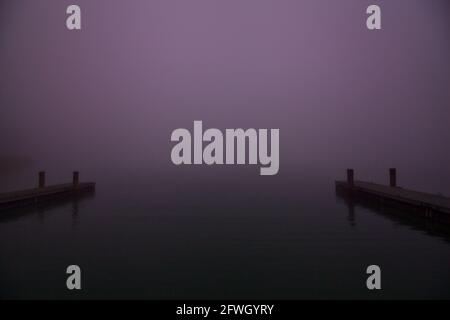 Ormeggia su un lago in una giornata di nebbia in inverno Foto Stock