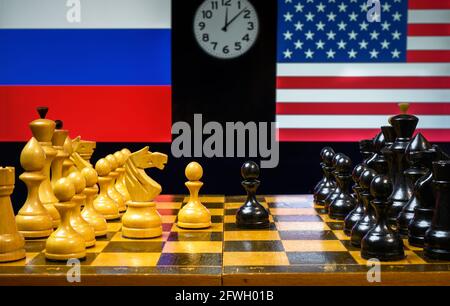 Russia vs USA, scacchi come gioco geopolitico. Bandiere di Stati Uniti e Federazione russa dietro scacchiera. Concetto di tensione politica, guerra economica Foto Stock