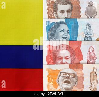 Denaro colombiano, pesos, sullo sfondo dei colori della bandiera nazionale Foto Stock