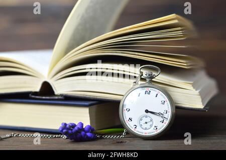 Buon giorno dei Padri. Orologio da tasca d'epoca, libri e fiori su sfondo di legno Foto Stock