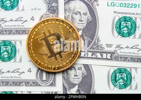 Calgary, Alberta, Canada. 22 maggio 2021. Un Bitcoin con un dollaro bollette sullo sfondo. Foto Stock