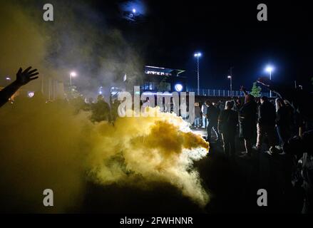 Dresda, Germania. 22 maggio 2021. Calcio: 3. campionato, SV Wehen Wiesbaden - Dynamo Dresden, 38. giorno di festa. I giocatori di Dynamo sono accolti dai tifosi di fronte al centro di allenamento con Bengalos dopo aver vinto il terzo campionato e arrivando da Wiesbaden. Credit: Robert Michael/dpa-Zentralbild/dpa/Alamy Live News Foto Stock