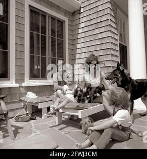 Il presidente John F. Kennedy, First Lady Jacqueline Kennedy, e i loro figli, Caroline Kennedy e John F. Kennedy, Jr., giocano con i loro cani, Shannon, Wolf, White Tips, Blackie, Clipper, e Charlie, a Brambletyde casa su Squaw Island, Hyannis Port, Massachusetts. Foto Stock