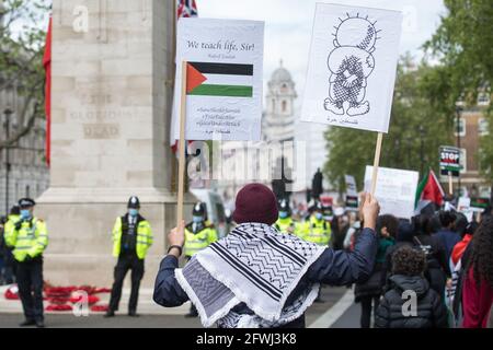 Londra, Regno Unito. 22 maggio 2021. Un uomo passa il Cenotaph tenendo un cartello con l'immagine di Handala durante la dimostrazione Nazionale per la Palestina. E' stato organizzato da gruppi di solidarietà pro-palestinesi in protesta contro i recenti attacchi di Israele a Gaza, le sue incursioni alla moschea di al-Aqsa e i suoi tentativi di spostare forzatamente le famiglie palestinesi dal quartiere Sheikh Jarrah di Gerusalemme Est. Credit: Mark Kerrison/Alamy Live News Foto Stock