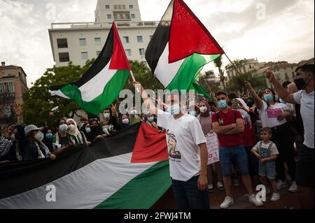 Malaga, Spagna. 22 maggio 2021. I manifestanti che indossano la maschera facciale sono visti detenere bandiere palestinesi mentre prendono parte a una protesta a sostegno della popolazione palestinese.dopo i bombardamenti su Gaza e i violenti attacchi tra le forze di sicurezza israeliane e i palestinesi a Gerusalemme, Un accordo di cessate il fuoco è stato stipulato tra Israele e Hamas sulla striscia di Gaza con centinaia di morti. (Foto di Jesus Merida/SOPA Images/Sipa USA) Credit: Sipa USA/Alamy Live News Foto Stock