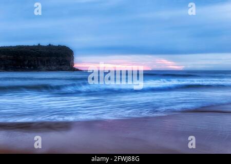 L'alba rosa dietro la punta di Mona vale sulla costa pacifica di Sydney - scenografico lungomare al largo della spiaggia di Mona vale. Foto Stock