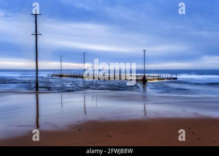 Piscina di roccia disconnessa dalla spiaggia di Mona vale sulle spiagge settentrionali di Sydney al sunrsise. Foto Stock