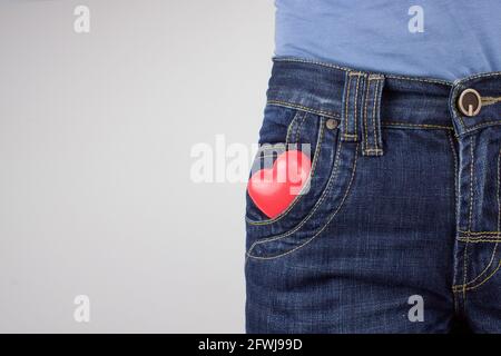 Cuore rosso in tasca di jeans. Rapporto tra le persone Foto Stock