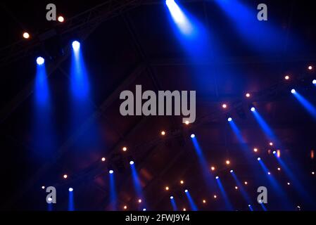 Luci offuscate sul palco che si illuminano al buio in un concerto dal vivo. Concetto di festival musicale Foto Stock