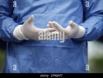 Dettagli con le mani di un medico in guanti chirurgici che si gesticulano mentre si parla. Foto Stock