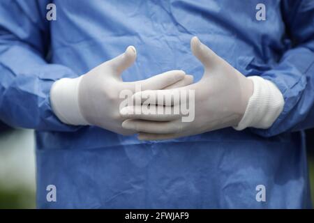 Dettagli con le mani di un medico in guanti chirurgici che si gesticulano mentre si parla. Foto Stock