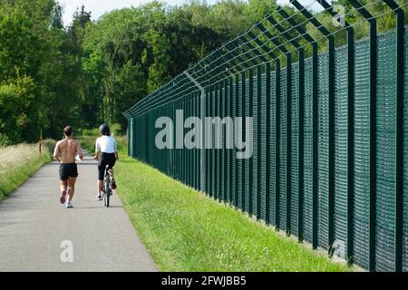 Kloten, Svizzera 05 24 2020: L'uomo fa jogging e la donna lo accompagna in bicicletta. Foto Stock