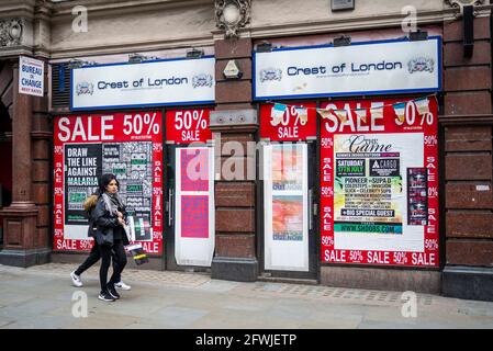 Chiuso il negozio di souvenir turistico di Londra durante la pandemia COVID 19 con cartelli di vendita a metà prezzo, coperto da volantini pubblicitari. Adesivi per fatture, poster Foto Stock