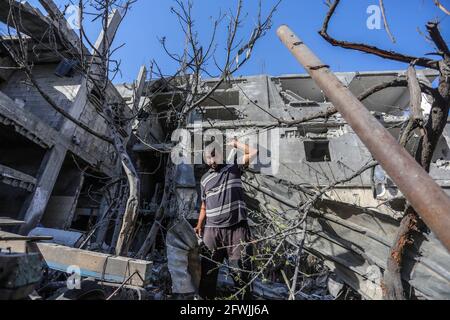 Gaza, Palestina. 21 Maggio 2021. Un uomo palestinese si trova tra le macerie di una casa distrutta dopo un cessate il fuoco tra Israele e i combattenti di Gaza nella città di Beit Hanun, nella parte settentrionale della striscia di Gaza. Dopo 11 giorni di combattimenti, il cessate il fuoco è entrato in vigore tra Israele e i militanti della striscia di Gaza sotto la supervisione di un'iniziativa egiziana per fermare il fuoco incondizionato. Almeno 232 palestinesi sono stati uccisi nell'attacco israeliano secondo il Ministero della Salute palestinese, mentre almeno 12 Israeliti sono stati uccisi in attacchi a razzo da Gaza. Credit: SOPA Images Limited/Alamy Live News Foto Stock